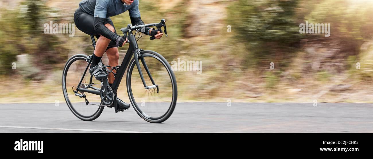Junger Mann, der seine Radfahrkünste zeigt, während er draußen auf dem Fahrrad unterwegs ist. Adrenalin-Junkie übt ein Speed-Rennen im Freien. Nicht erkennbarer Mann Stockfoto