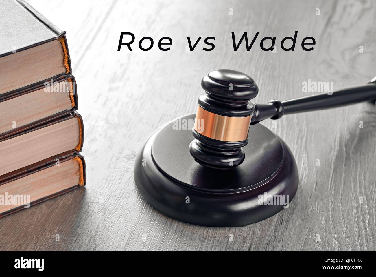 Roe versus Wade Text. Gesetzhammer und alte Bücher auf Holztisch. Stockfoto