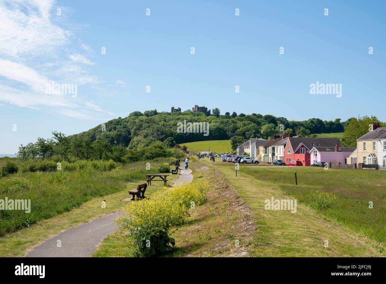 Gesamtansicht von Llansteffan in Carmartheshire, Wales, mit der Burg im Hintergrund an einem sonnigen Tag im Sommer. Stockfoto