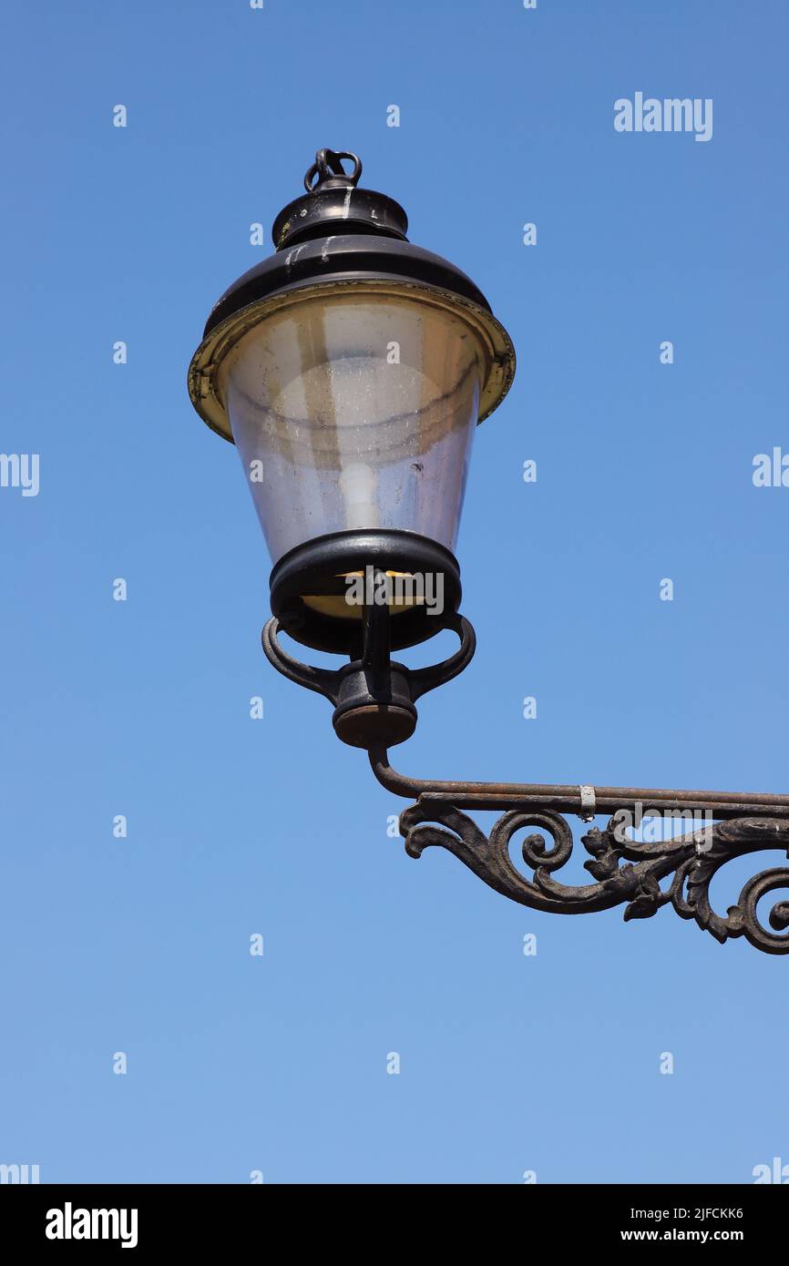 Nahaufnahme einer altmodischen elektrischen Laterne vor einem klaren blauen Himmel. Stockfoto