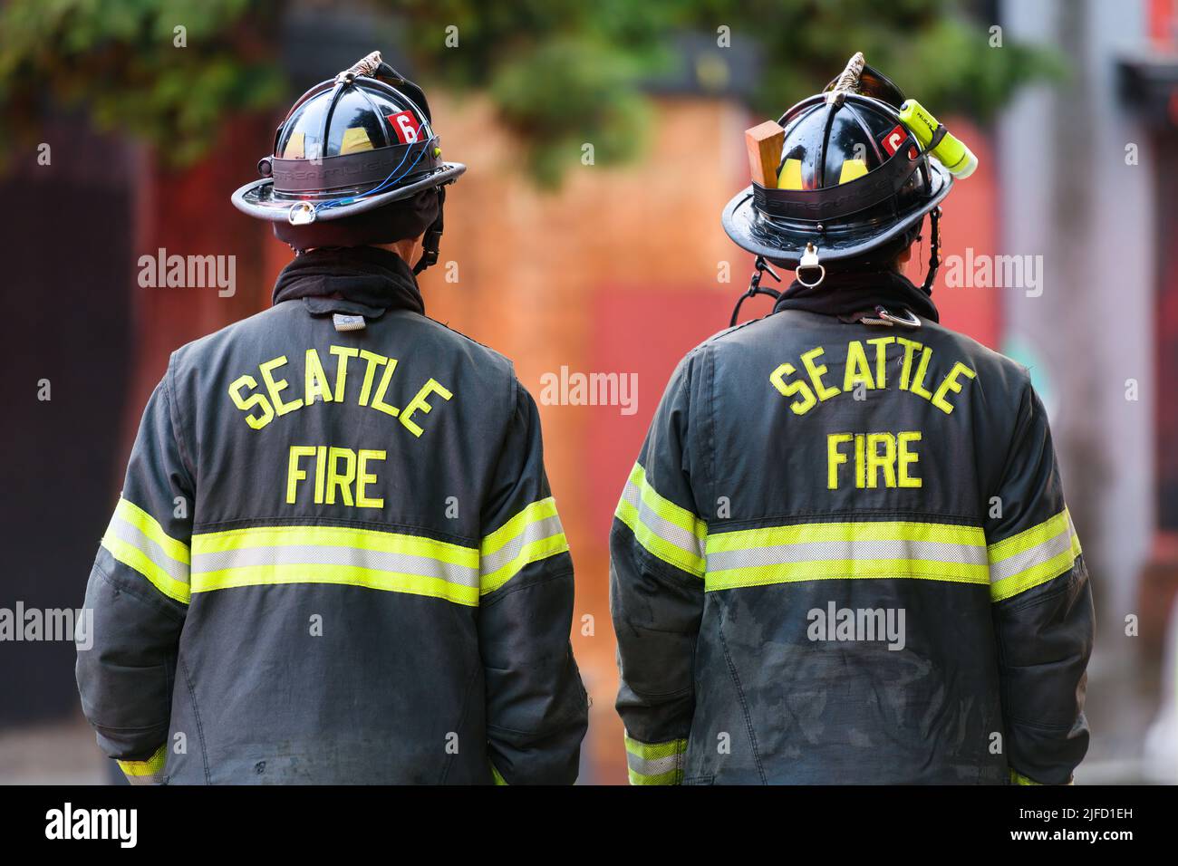 Seattle - 30. Juni 2022; zwei Seattle-Feuerwehrmänner von hinten im Einsatz gesehen. Seattle Fire ist im Text auf ihrem Rücken mit gut sichtbaren Markierungen Stockfoto