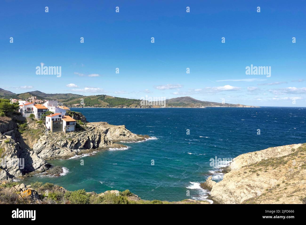 Ein malerischer Blick auf Häuser auf einer felsigen Klippe vor einem blauen Meer an einem sonnigen Tag Stockfoto