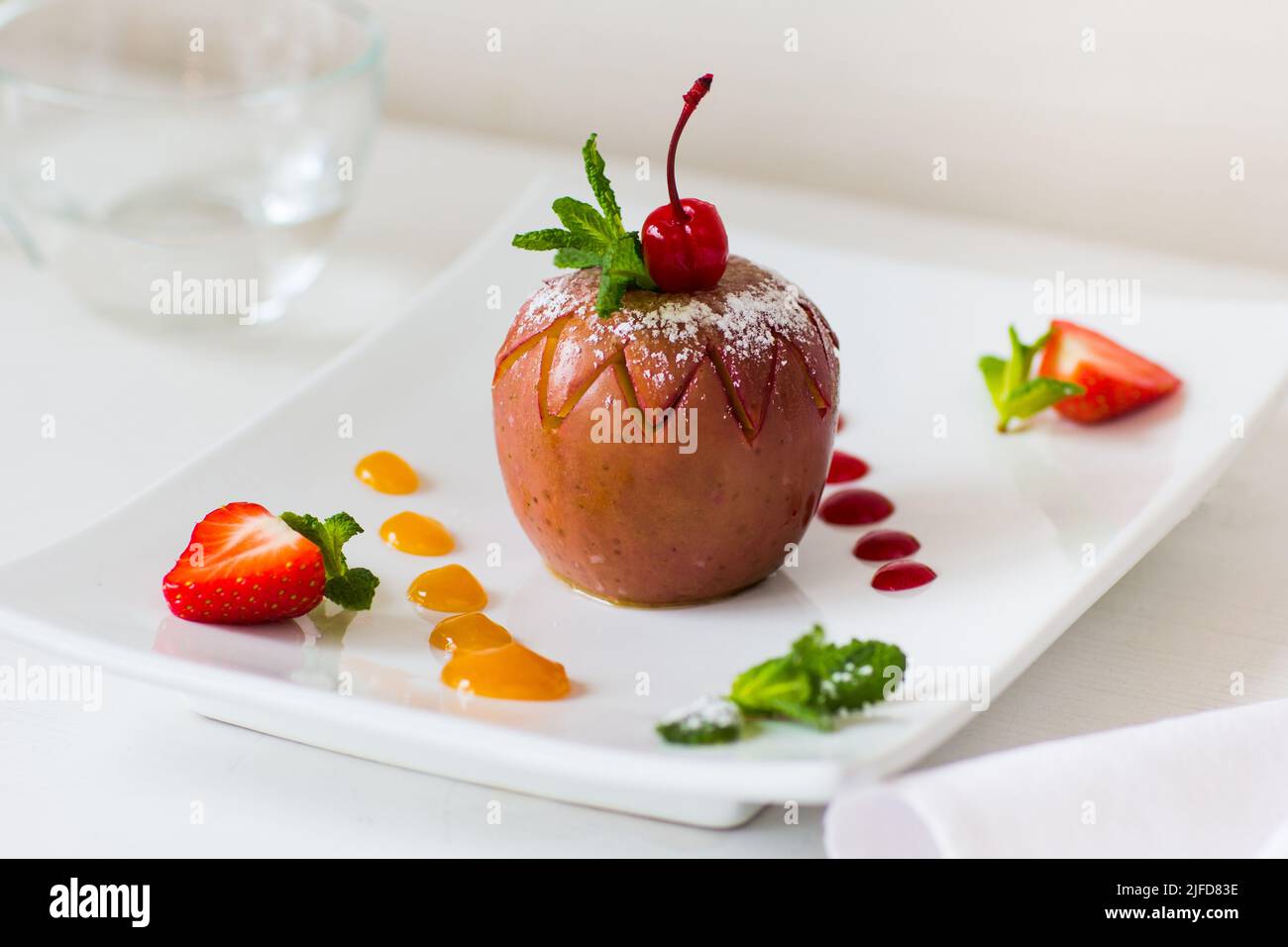 Gebackener Apfel mit Obstmarmelade auf dem Teller Stockfoto