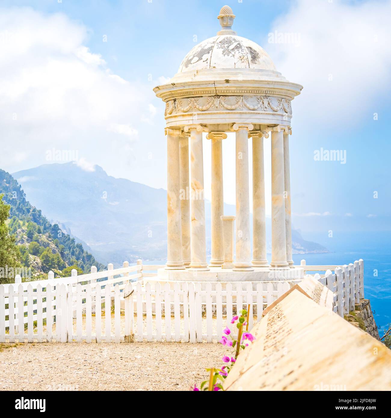 Marmortempel Son Marroig auf einer umzäunten Plattform mit einer Wand und rosa Blumen vor der nordwestlichen Küste Mallorcas in den Bergen der Serra de Tramuntana Stockfoto
