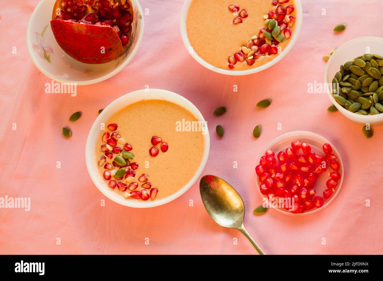 Frischer, hausgemachter Vanillepudding, serviert in einer Schüssel mit Belag aus Granatapfelkernen. Schale isoliert auf hellem Hintergrund.Draufsicht,Text kopieren. Stockfoto