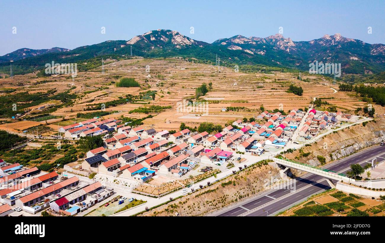 (220702) -- JINAN, 2. Juli 2022 (Xinhua) -- Luftfoto vom 18. Juni 2022 zeigt eine Ansicht des Dorfes Hongniya im Landkreis Wulian in Rizhao, der ostchinesischen Provinz Shandong. Das Dorf Hongniya war früher ein von Armut gebeuteltes Dorf. In den letzten Jahren hat der Dorfkader Zhang Shouying eine Reihe von Maßnahmen ergriffen, um den Dorfbewohnern zu helfen, die Armut zu beseitigen und ein besseres Leben zu führen. Im Jahr 2021 entwickelte das Dorf Hongniya unter professioneller Anleitung der Landwirtschaftlichen Universität Shandong den Anbau von essbaren Pilzen, was dazu beigetragen hat, das Einkommen der Dorfbewohner zu steigern und die ländliche Revitalisierung zu fördern. (Xinhua/Guo Xul Stockfoto