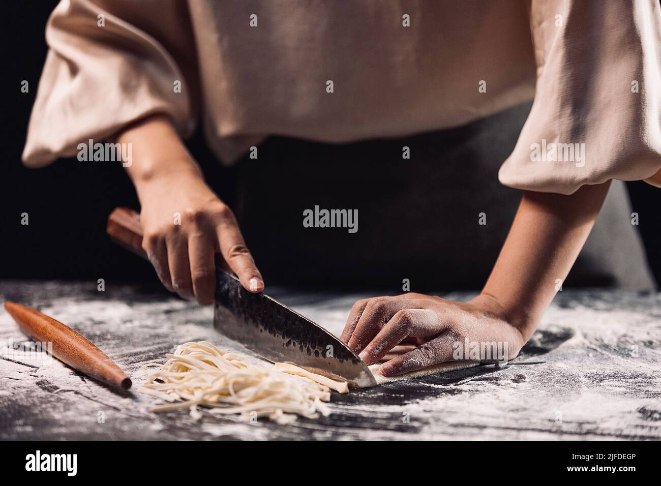 Schneiden Teigstück in Nudeln, der Prozess der Herstellung von traditionellen chinesischen Küche handgerollte Nudeln - Stock Foto Stockfoto