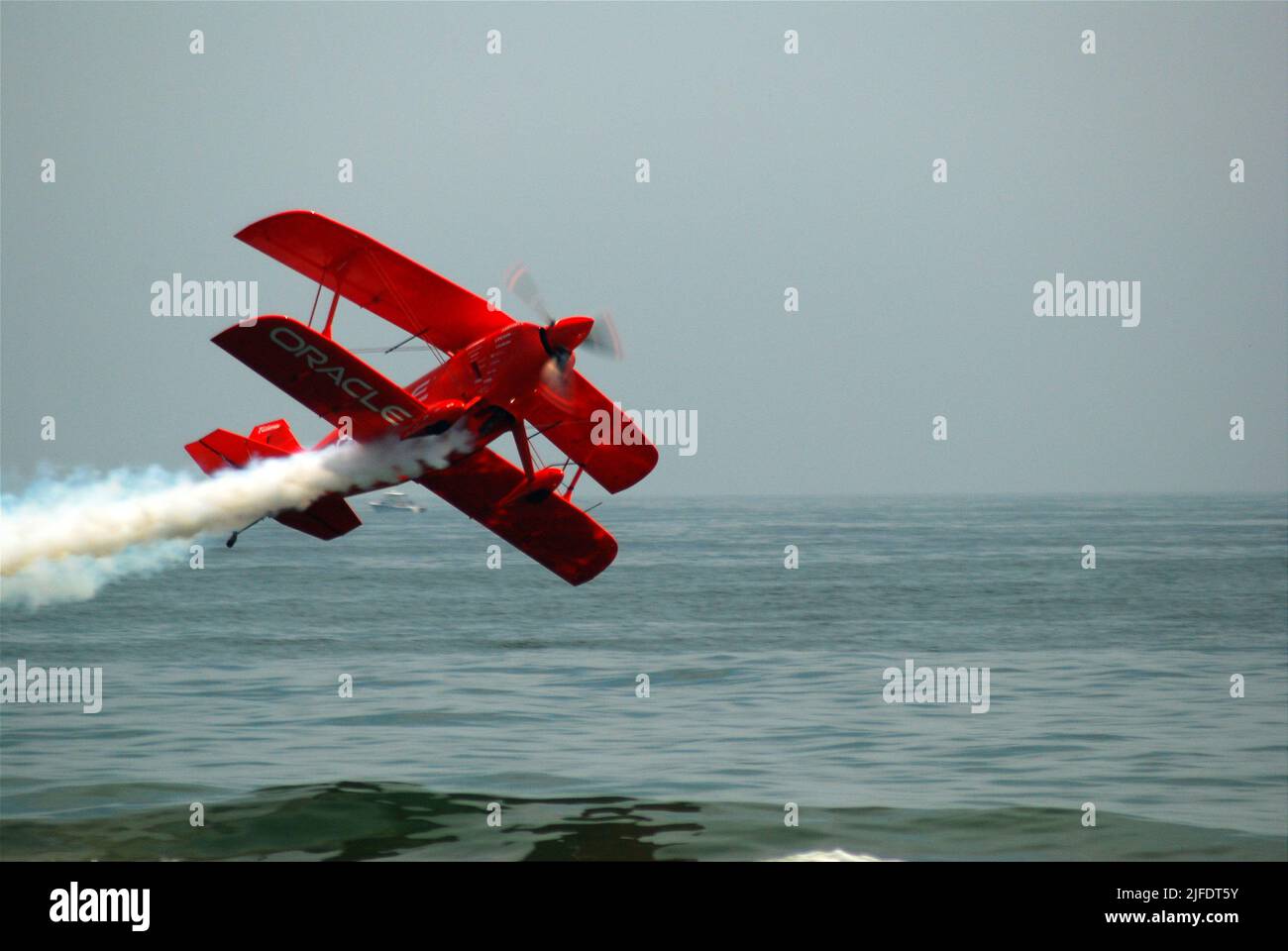 Ein Stuntpilot fliegt sein Doppelflugzeug während einer Flugshow am Jones Beach, Long Island, gefährlich nahe am Meer Stockfoto
