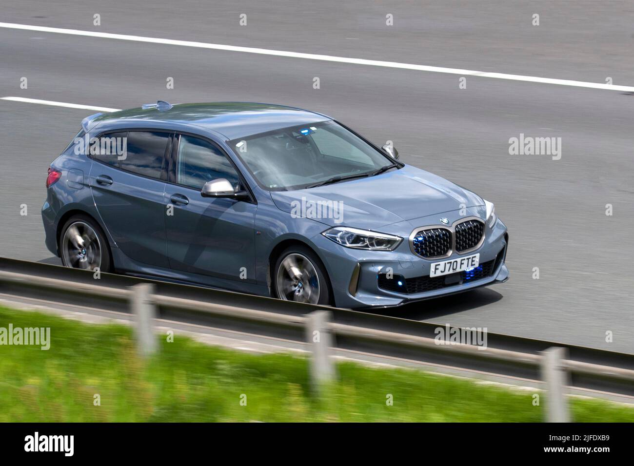 Polizei, unmarkiertes Fahrzeug. Autobahn Patrol Car mit versteckten blauen Lichtern. 2020 Grauer BMW M135i X Drive Auto Start Stop 1998cc Benzin-Heckklappe Fahrt mit Geschwindigkeit auf der Autobahn M6 in Lancashire, Großbritannien Stockfoto