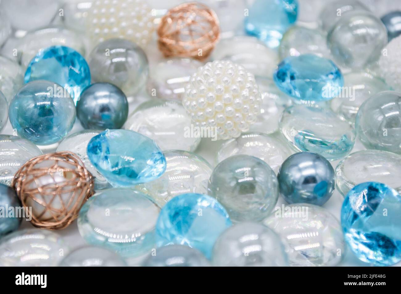 Schöner Hintergrund aus transparenten, hellblauen Glasperlen, Kristallen und weißen Perlen. Speicherplatz kopieren. Stockfoto