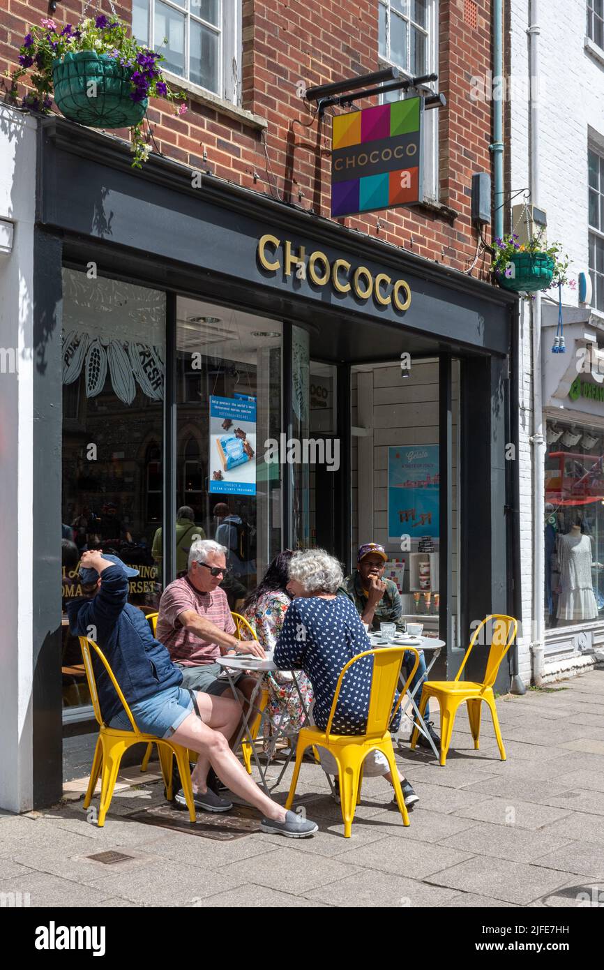 Chococo Schokoladengeschäft in der Winchester High Street mit Menschen, die draußen sitzen, Hampshire, England, Großbritannien Stockfoto