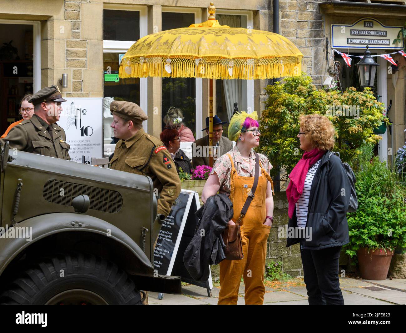 1940er Jahre nostalgische lebendige Geschichte Nachinszenierung Wochenende (Männer in WW2 Kostüm, Menschen im Gespräch) - Haworth Main Street, West Yorkshire, England Großbritannien. Stockfoto