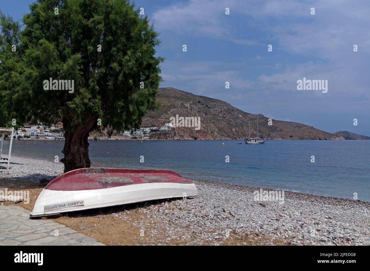 Umgedrehtes griechisches Fischerboot unter einem Tamarisken. Marco Polo, Strandszene, Dorf Livadia, Insel Tilos, Dodcanese, Griechenland Stockfoto