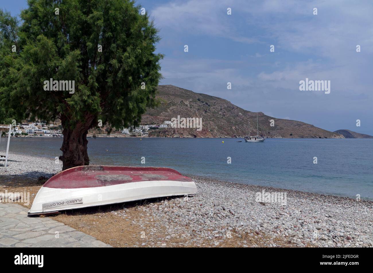 Umgedrehtes griechisches Fischerboot unter einem Tamarisken. Marco Polo, Strandszene, Dorf Livadia, Insel Tilos, Dodcanese, Griechenland Stockfoto