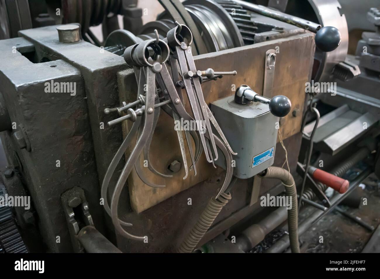 Nahaufnahme einer speziellen Messausrüstung wie Bremssättel, Teiler & Kompass von alten Drehmaschinen. Vintage Industriemaschinen in einer alten Fabrik. Stockfoto