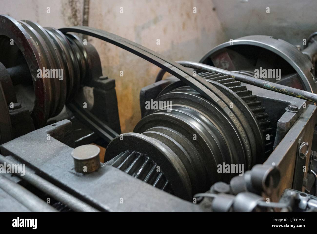 Nahaufnahme von öligen Metallgetrieben und Riemen von alten Drehmaschinen. Stockfoto