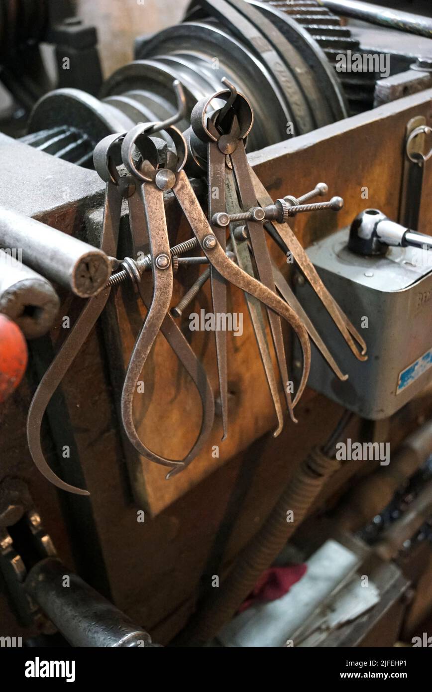 Nahaufnahme einer speziellen Messausrüstung wie Bremssättel, Teiler & Kompass von alten Drehmaschinen. Vintage Industriemaschinen in einer alten Fabrik. Stockfoto