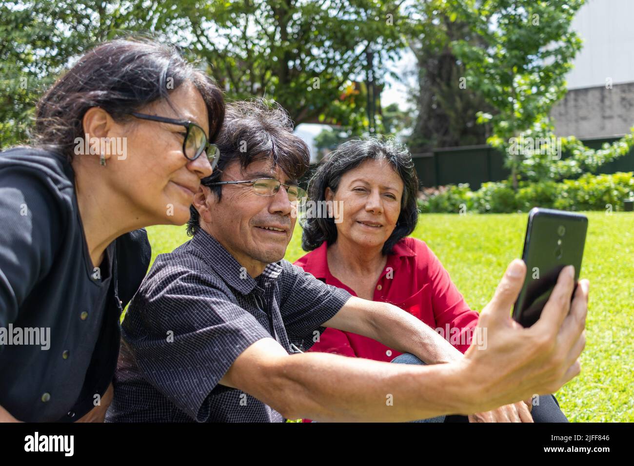 Gruppe von lateinamerikanischen Freunden mittleren Alters, die ein Selfie machen und Spaß in einem Park haben Stockfoto