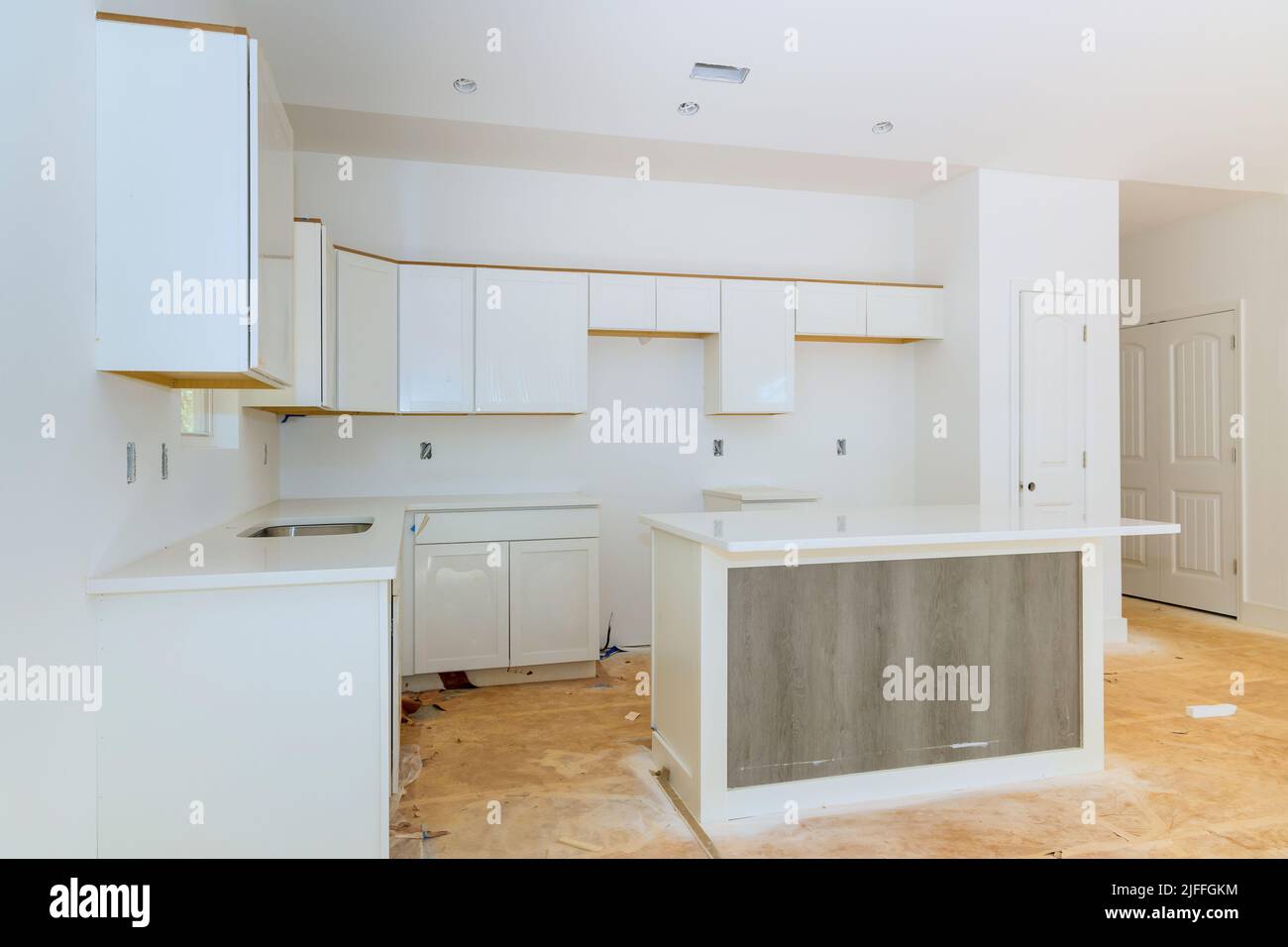 In einer Reihe von Möbeln im Bau wurden weiße Küchenschränke aus Holz installiert Stockfoto
