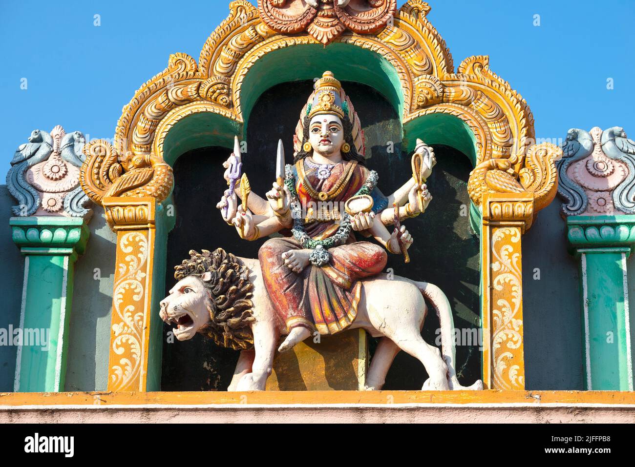 TRINCOMALEE, SRI LANKA - 09. FEBRUAR 2020: Die achtarmige Göttin Durga reitet auf einem Löwen. Skulptur auf dem Giebel des alten Hindu-Tempels Sri Bhadrak Stockfoto