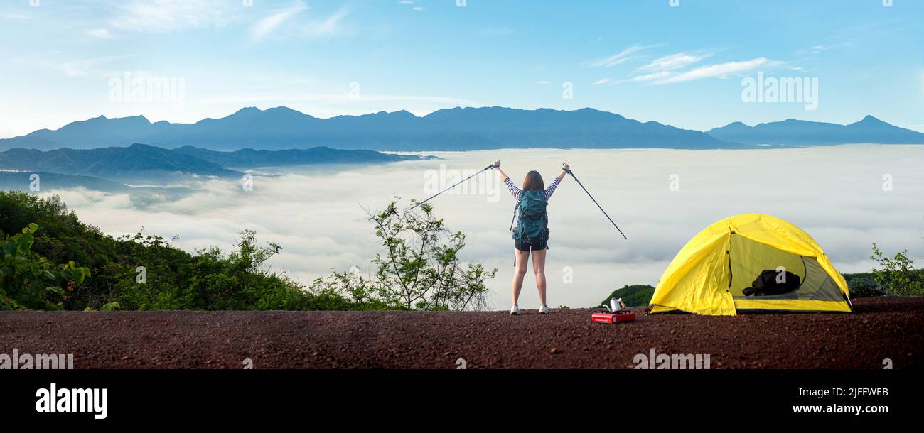 Weibliche Wanderer genießen auf der Spitze der Klippe Berg.Sie genießen die Freiheit in Berg Nebel bei Sonnenaufgang. Stockfoto