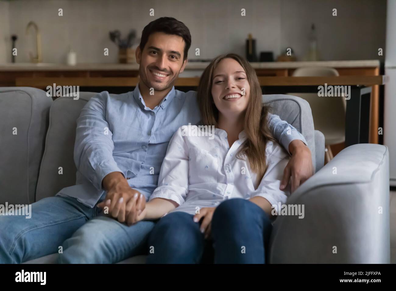 Schöne verheiratete Paar Ruhe auf Couch Pose Blick auf die Kamera Stockfoto