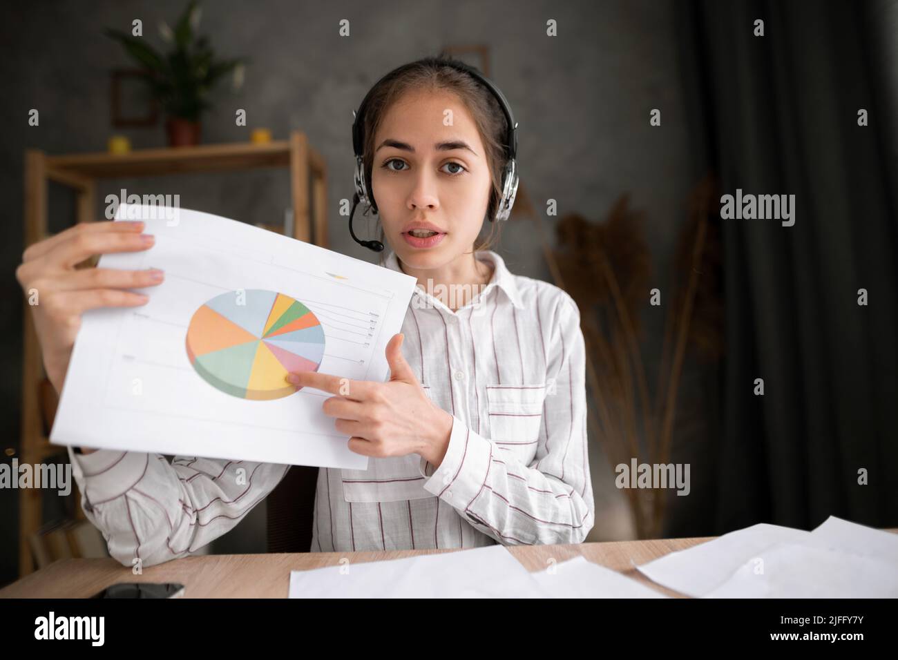 Die junge hispanische Frau präsentiert das Business Chart-Projekt zur Zusammenarbeit mit Kollegen in der Telekonferenz und präsentiert den Projektzeitplan. Videokonferenz Stockfoto