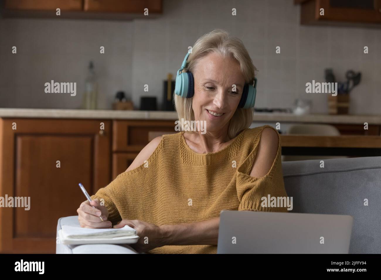Ältere Frauen mit Kopfhörern, die online zu Hause E-Learning-Kurse machen, verwenden einen Laptop Stockfoto