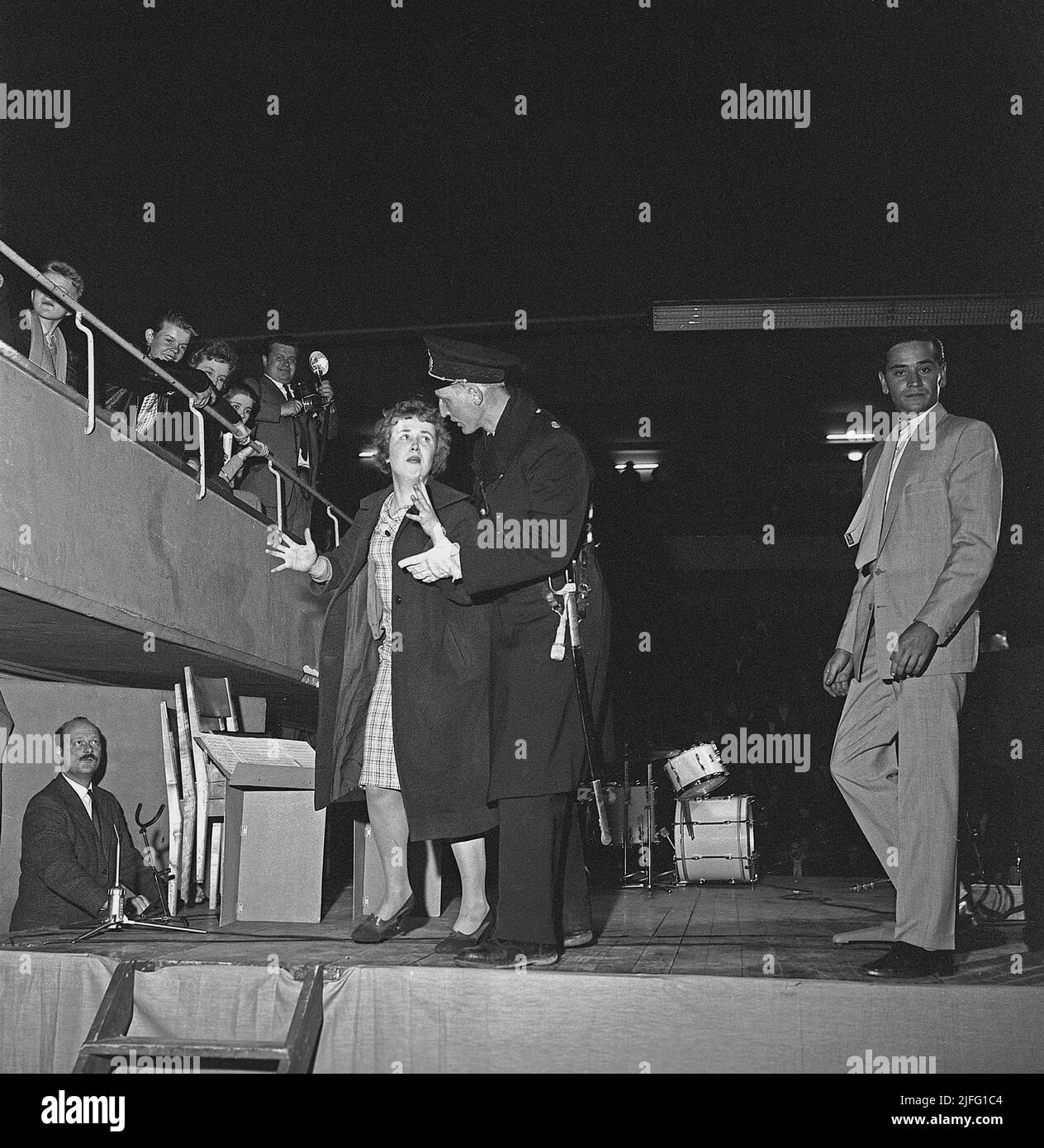 Tommy Steele. Der englische Entertainer gilt als Großbritanniens erstes Teenager-Idol und Rock and Roll-Star. Geboren im dezember 17 1936. Foto, aufgenommen als er im April 19 1958 in Stockholm in Schweden auftrat. Eine Frau aus dem Publikum hat die Chance genutzt, auf die Bühne zu kommen, um ihr Idol zu umarmen, und wird von einem Polizisten von der Bühne genommen. Stockfoto