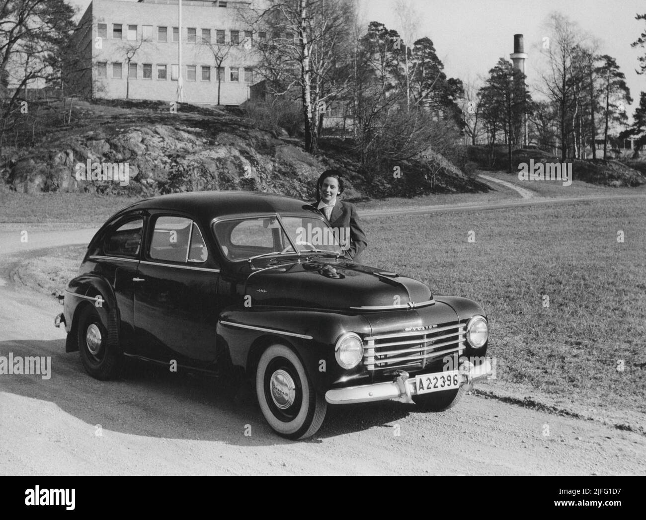 Volvo Auto in der 1950s. Der Volvo PV 444 war eines der beliebtesten Volvo-Fahrzeuge aller Zeiten und war ein Volkwagen der schweden. 196005 Autos wurden hergestellt und es verfügte über einen geräumigen Kofferraum, gute Rostbeständigkeit, die Möglichkeit, das Fahrzeuginnere in ein Bett und Volvo-Service zu verwandeln. Das Bild zeigt einen stolzen Volvo-Besitzer im Jahr 1950s. Stockfoto