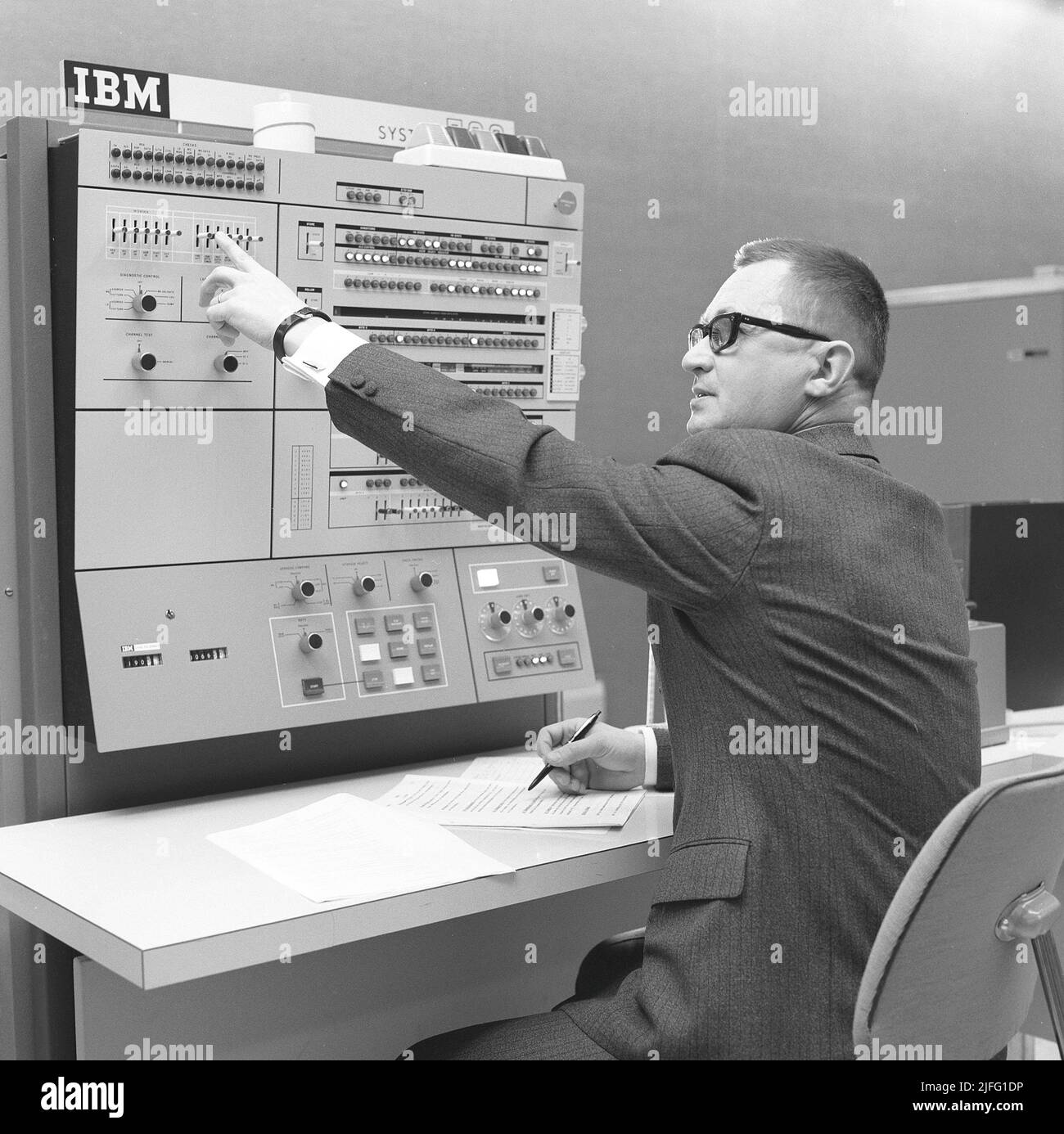 In der 1960s. Innenraum eines Raumes mit Computern und Menschen, die mit ihnen umgehen und Informationen registrieren und lesen. Auf einem Schild über dem Mainframe-Computer steht IBM 360. IBM System 360 wurde häufig in der amerikanischen Fernsehserie Mad Men gesehen. Bild aufgenommen 1965 Kristoffersson Ref. DY125-1 Stockfoto