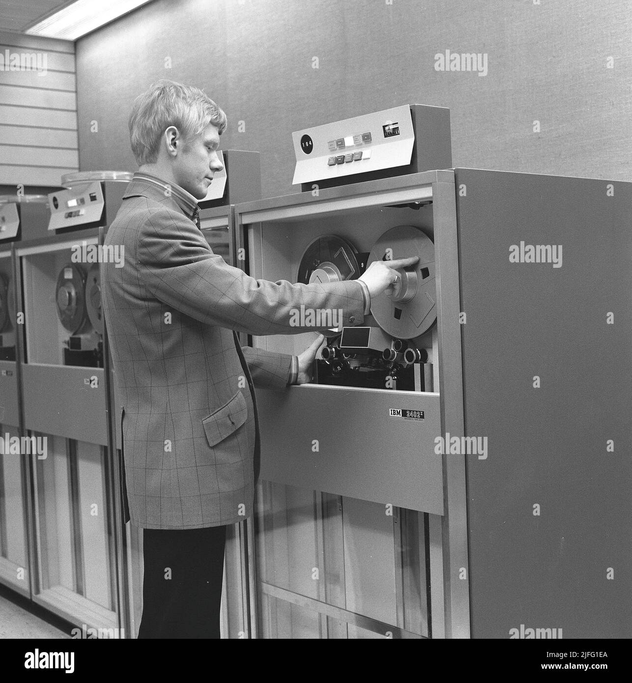 In der 1960s. Innenraum eines Raumes mit Computern und Menschen, die mit ihnen umgehen und Informationen registrieren und lesen. IBM System 360 mit einer Magnetbandeinheit der IBM 2402 2.-Generation, die verwendet wird, wenn das Band mit Informationen gelesen oder eingegeben wird. Bild aufgenommen 1965 Kristoffersson Ref. DY126-12 Stockfoto