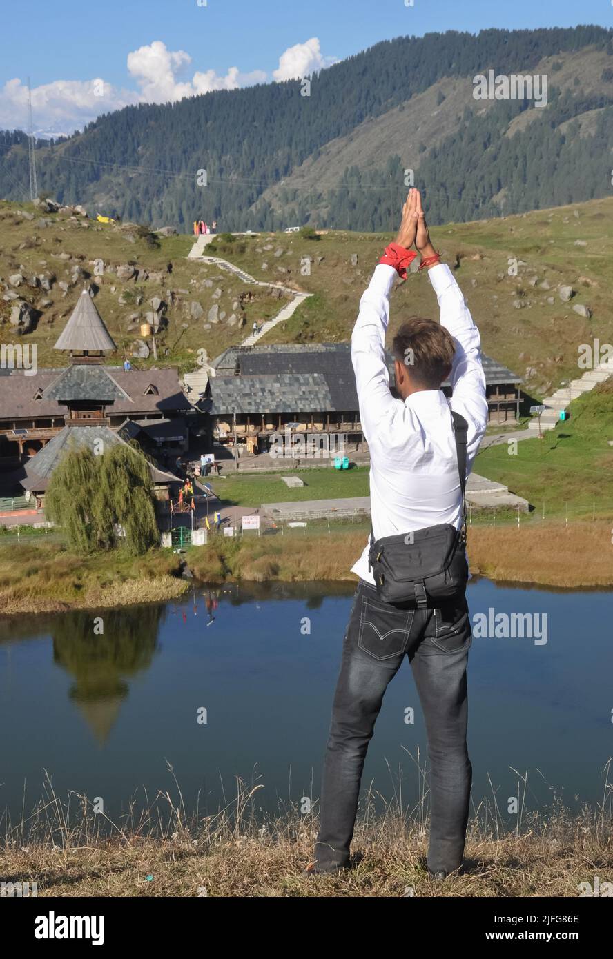 Rückansicht eines männlichen Touristen, der Namaste-Geste machte, während er in Richtung des Parashar rishi-Tempels in Mandi, Himachal Pradesh, Indien, stand Stockfoto