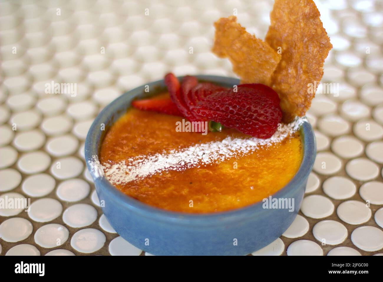 Eine Nahaufnahme von köstlichem Creme Brulee Dessert mit Erdbeere dekoriert Stockfoto