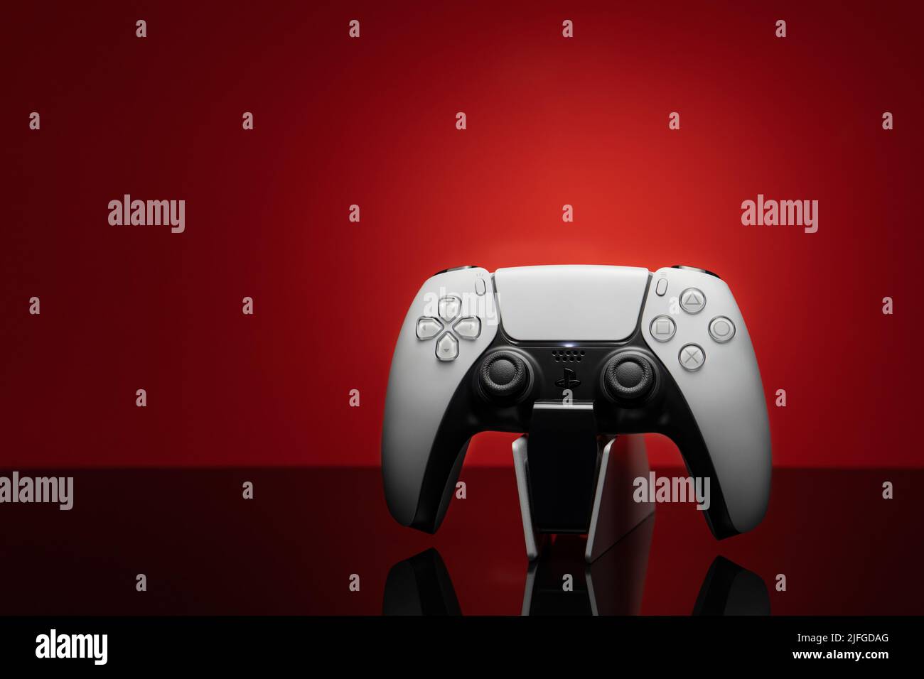 3. Dezember 2020, Odessa, Ukraine. Weißer neuer Gamepad-Dualsense für PlayStation 5 auf rotem Hintergrund. Cybersport Poster Konzept. Stockfoto