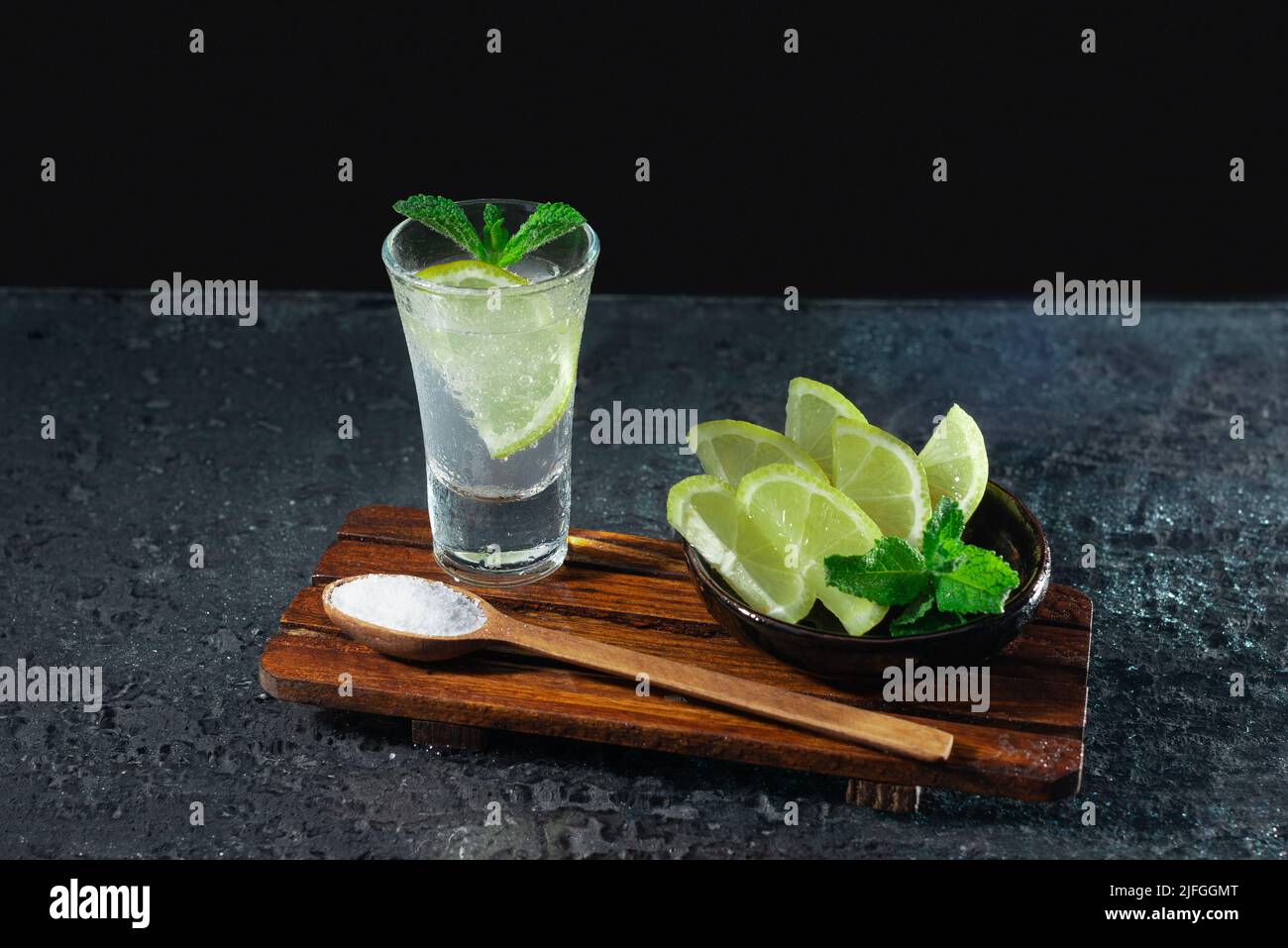 Mexikanischer Tequila mit Limette und Salz auf schwarzem Hintergrund. Platz für Text. Luxusgetränk-Konzept. Alkoholisches Getränk. Stockfoto