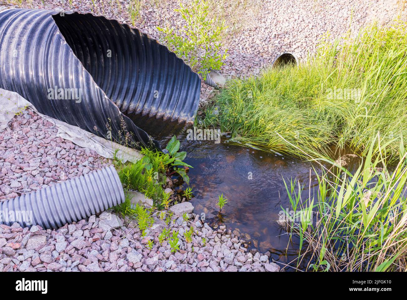 Blick auf die Entwässerungsleitungen, die auf der Straßenseite herauskommen. Gebäudetechnikkonzept. Schweden. Stockfoto