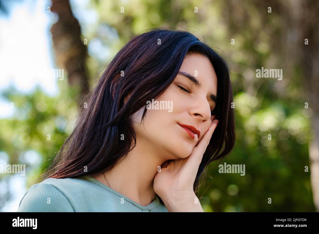 Schöne Brünette Frau trägt türkisfarbenes T-Shirt auf Stadtpark stehen, im Freien berühren Mund mit der Hand mit schmerzhaftem Ausdruck wegen Zahnac Stockfoto