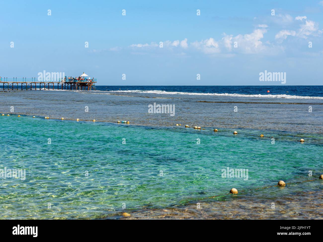 Schöne Meereslandschaft des Roten Meeres in der Nähe von Marsa Alam, Ägypten, Afrika. Die Wellen brechen auf dem Korallenriff, Pier über dem Riff zum Tauchen oder Schnorcheln. Stockfoto