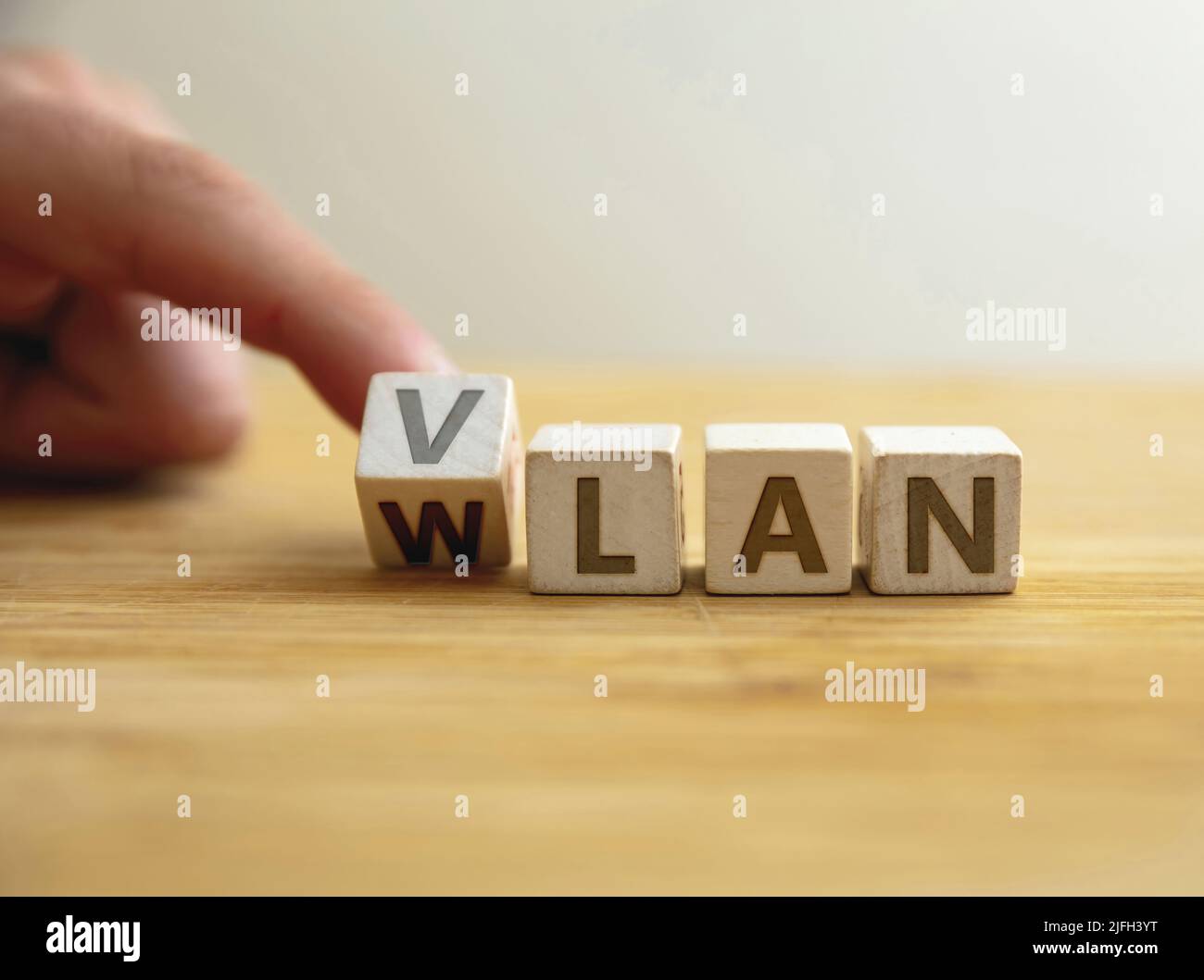 Konzept des VLAN-zu-wlan-Netzwerktyps. Finger dreht den Buchstaben auf den Holzwürfel und ändert das Wort vlan in wlan. Nachricht für Sicherheit mit logisch unabhängig Stockfoto Konzept des VLAN-zu-wlan-Netzwerktyps. Finger dreht den Buchstaben auf den Holzwürfel und ändert das Wort vlan in wlan. Nachricht für Sicherheit mit logisch unabhängig Stockfoto
