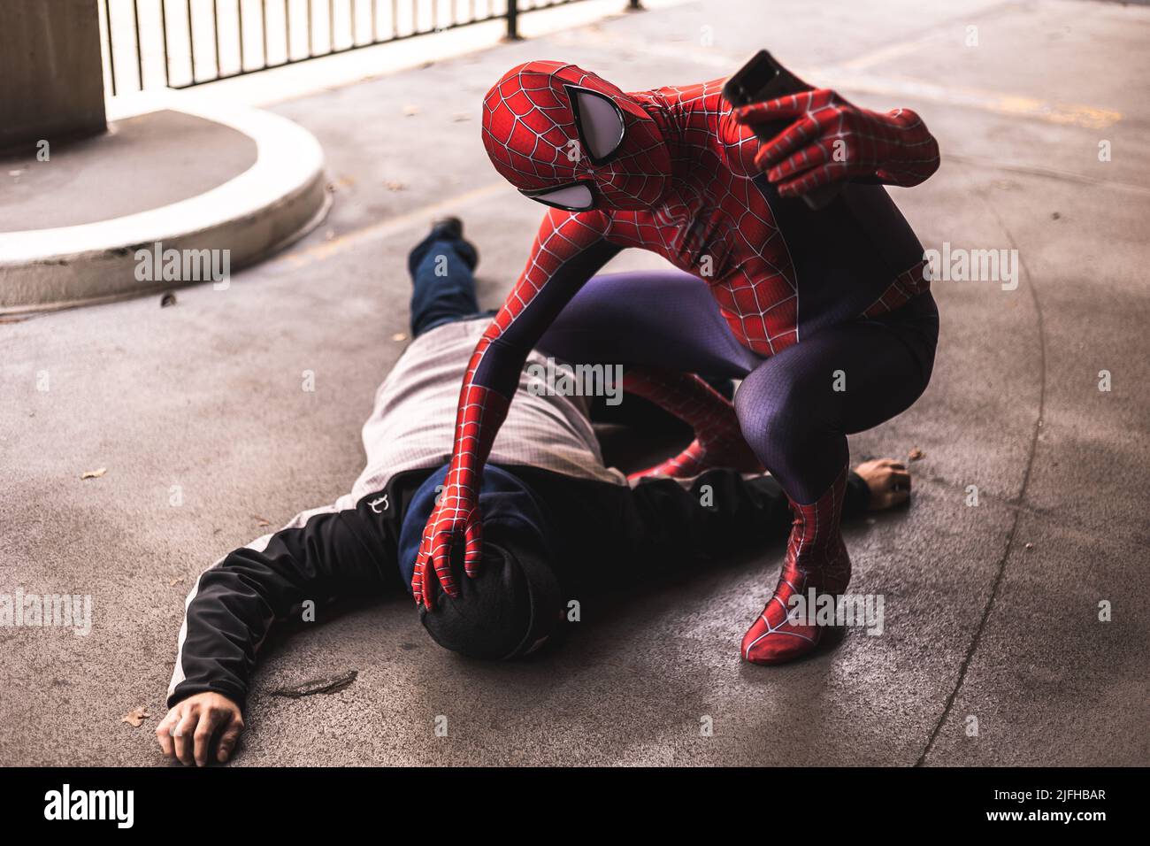 Spider-man macht ein Selfie mit dem besiegten Bösewicht. Berühmter Superheld, der die Innenstadt von Fort Worth in Texas, USA, besucht Stockfoto