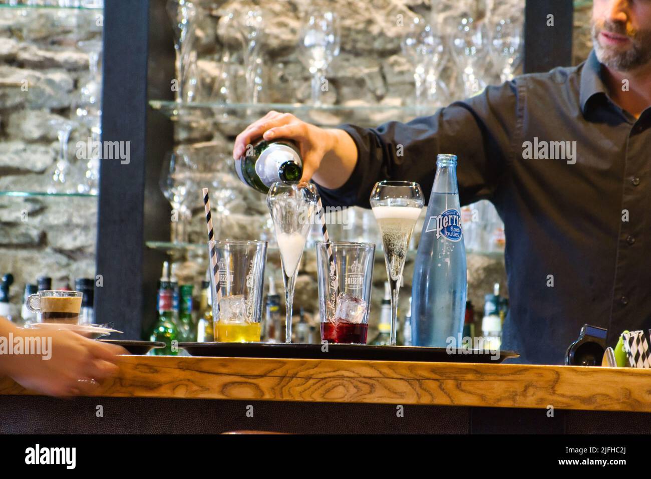 Der Barkeeper serviert einen Drink in einem französischen Pub Stockfoto