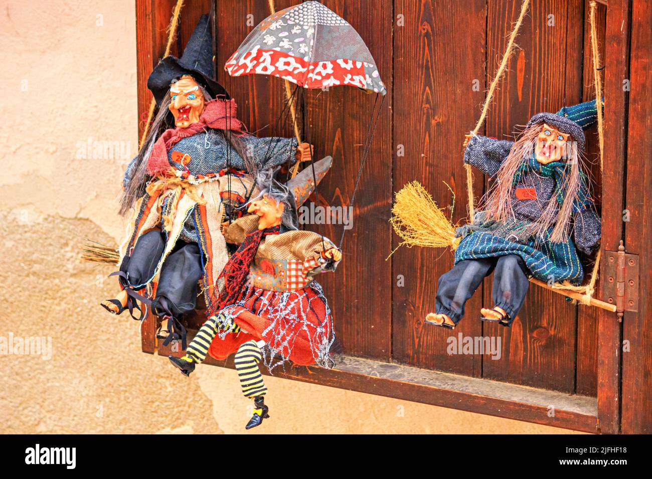 Stadtbild - Blick auf handgefertigte Puppenhexen, die an der Wand des Souvenirshows in der Altstadt von Cesky Krumlov, Tschechien, hängen Stockfoto