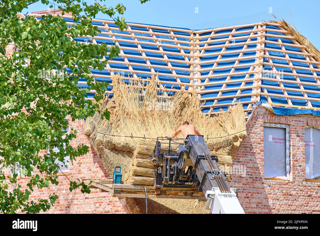 Reethaus wird am 29. Juni 2022 von einem Dachdecker-Handwerker in Oldsum bei Wyk, Föhr Island, Deutschland, abgedeckt und genäht. © Peter Schatz / Alamy Stock Photos Stockfoto