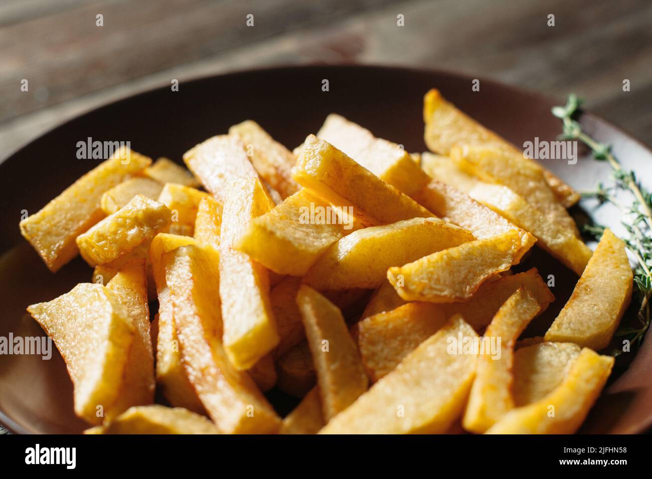 Gebratene Kartoffelkeile in Tonschüssel in Nahaufnahme Stockfoto