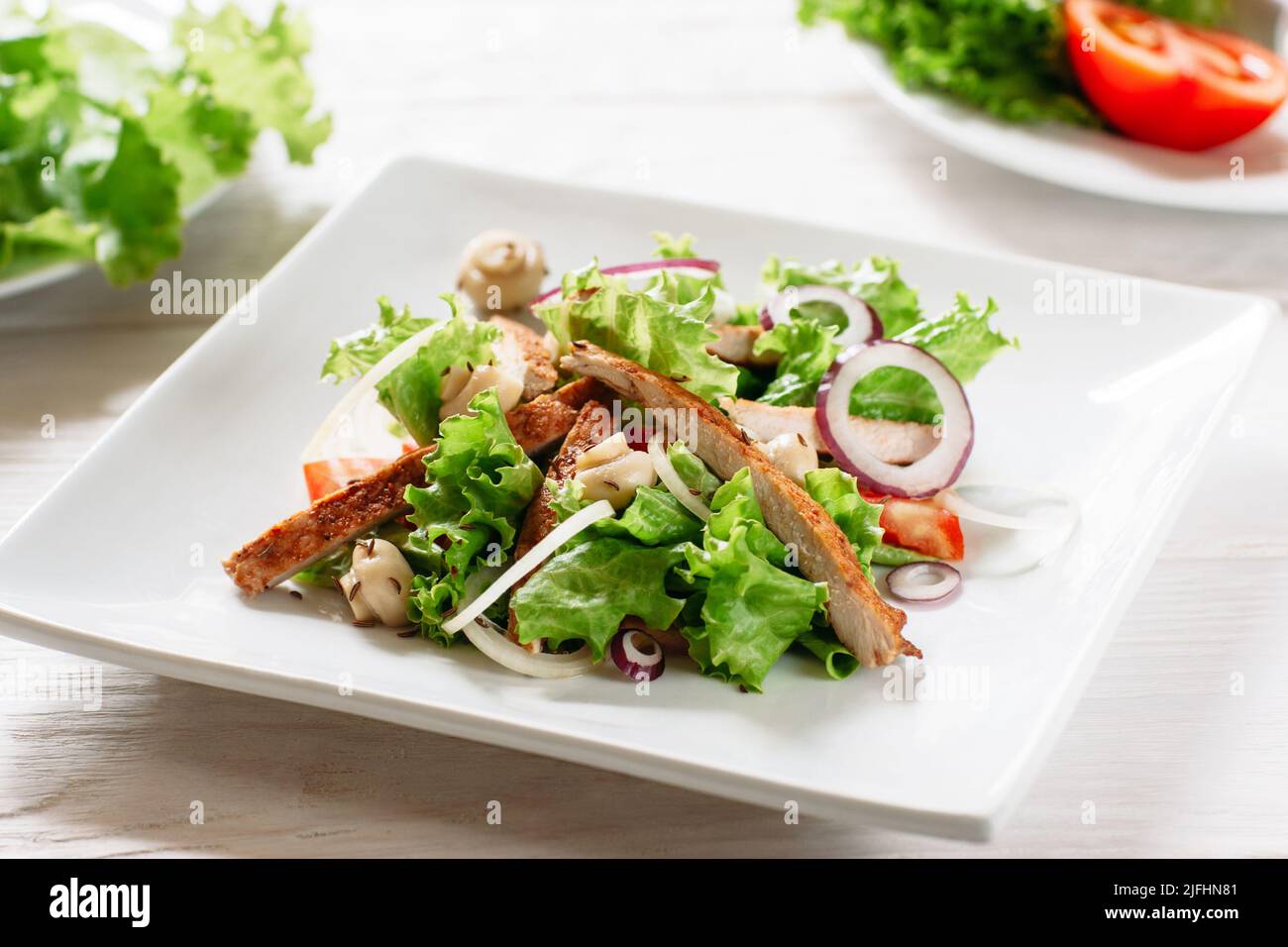 Teller mit Hühnersalat und Champignons aus der Nähe Stockfoto