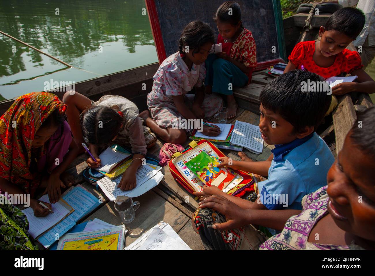 Zigeunerkinder besuchen eine schwimmende Schule auf einem Kanal in Sahapur in Sonargaon, Narayanganj, Bangladesch. Stockfoto