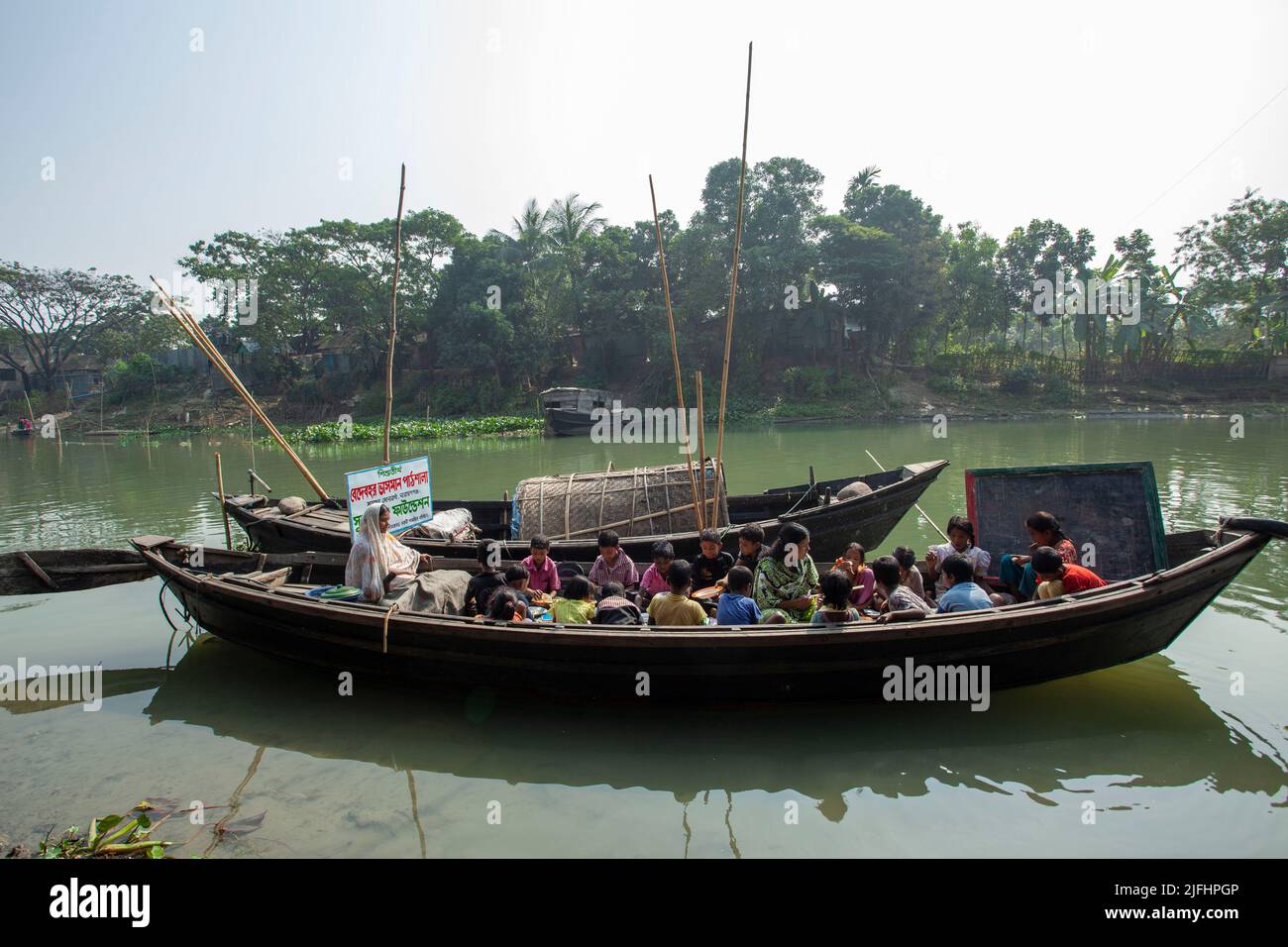 Eine schwimmende Schule auf einem kleinen Boot für Zigeunerkinder auf einem Kanal in der Nähe des Meghna-Flusses in Sahapur in Sonargaon, Narayanganj, Bangladesch. Stockfoto