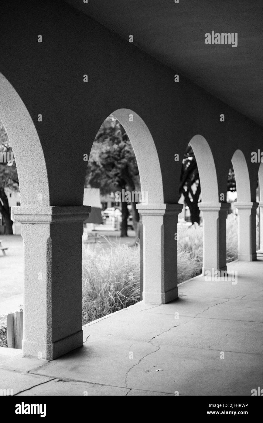 Eine Aufnahme von Bögen in Graustufen am Fort Worth Stock Exchange-Gebäude im historischen Texas Stockyards Stockfoto