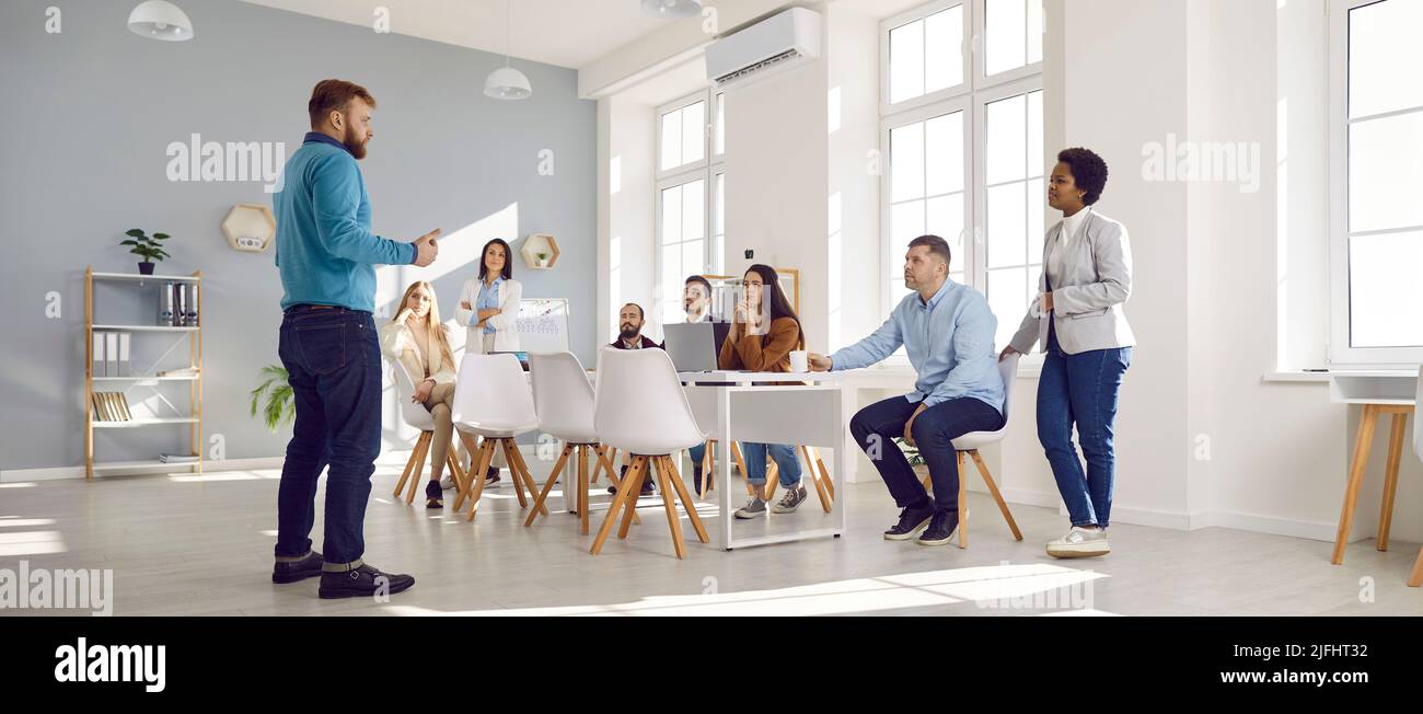 Corporate Business Manager im Gespräch mit einem Team von Menschen während eines Meetings im Büro Stockfoto